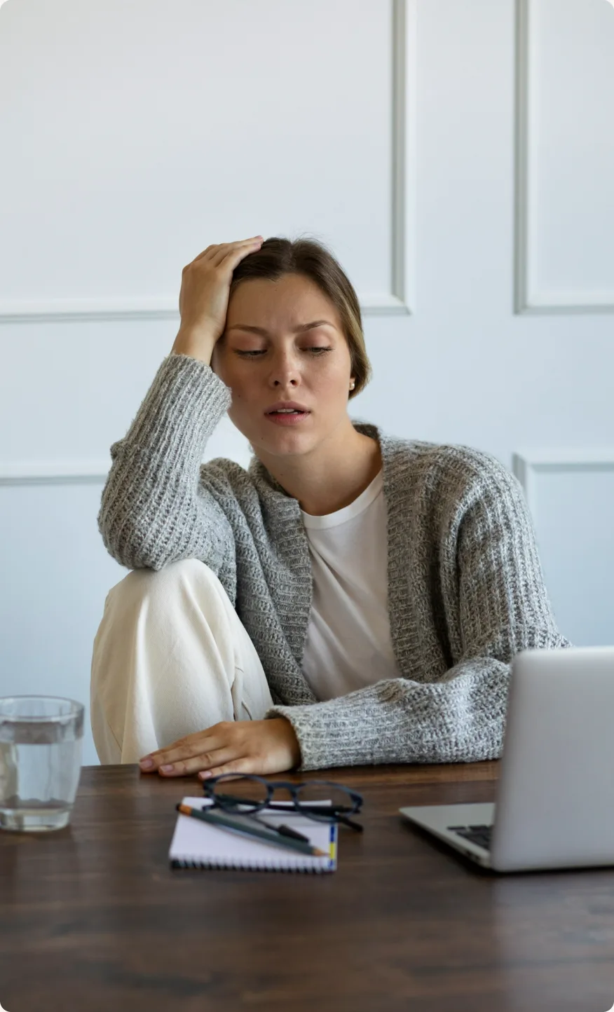 Mulher cansada apoiando a cabeça na mão em frente ao computador